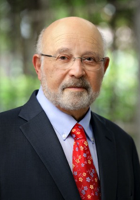 A man with a beard and glasses wearing a suit