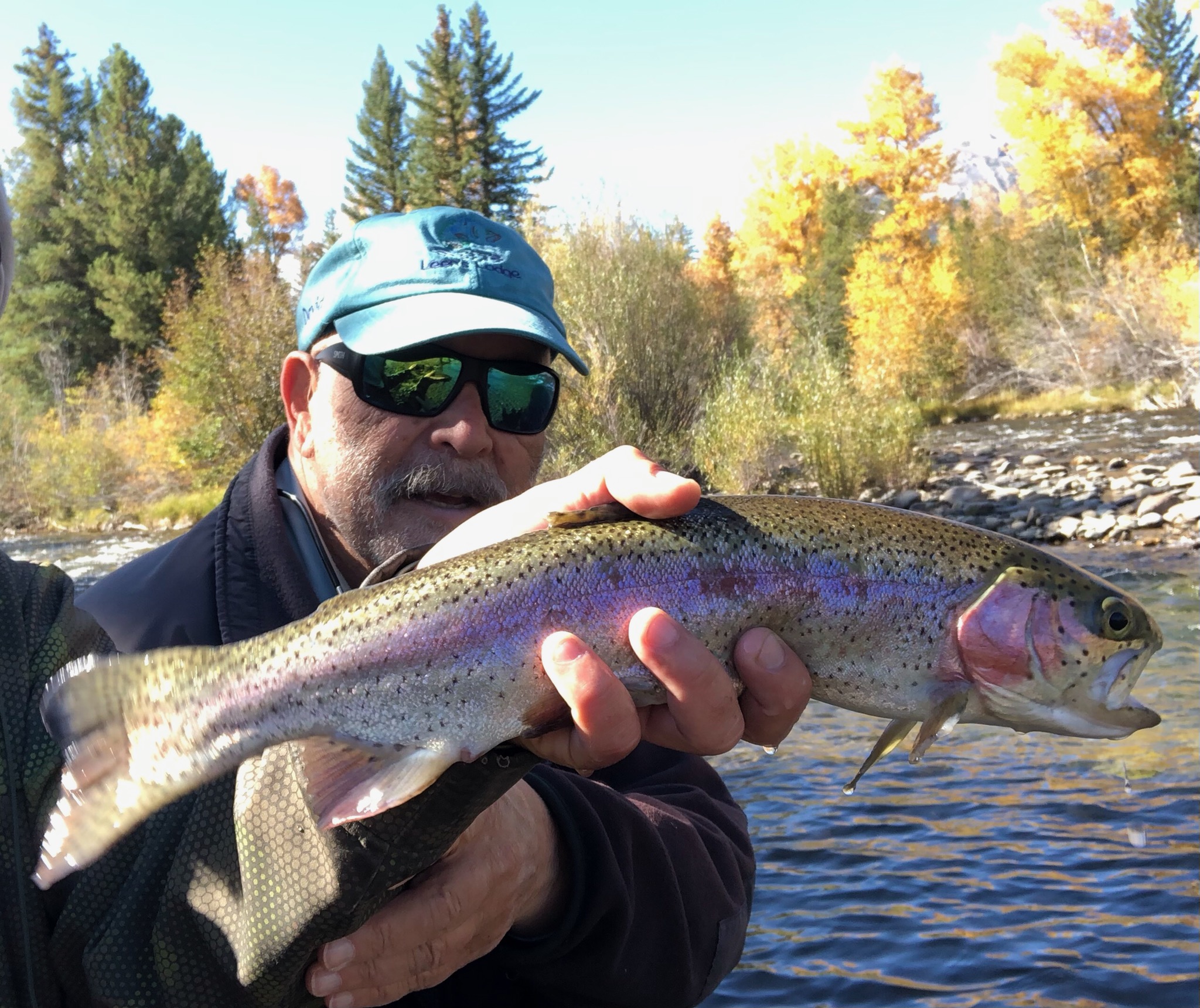 A man holding a rainbow trout in his hands.